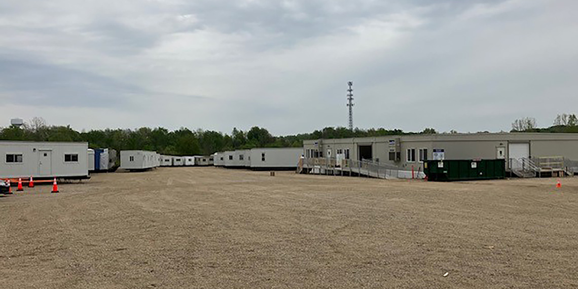 Grand Rapids dirt lot full of Willscot trailers against a backdrop of trees and gray sky
